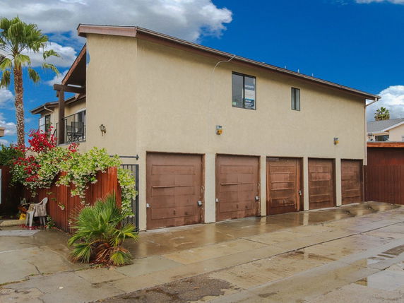 Front view of a two-story building with multiple wooden garage doors.