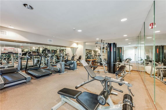 Indoor gym area with various exercise equipment including treadmills and weight machines.