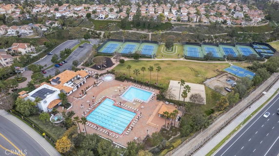 Aerial view of a recreational area with a swimming pool and multiple tennis courts.