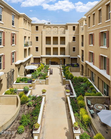 View of a multi-story residential building courtyard with landscaping.