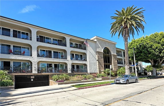 Front view of a three-story apartment building with balconies.