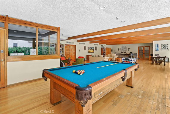 Indoor clubhouse area with a billiards table and seating in a spacious room.
