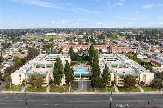 Panoramic view of residential buildings with swimming pool in the center, surrounded by a neighborhood.