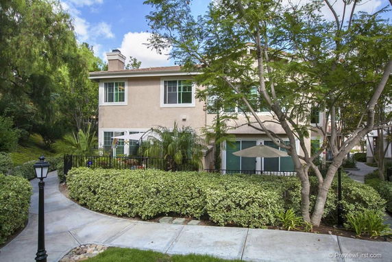 Front view of a two-story house with surrounding greenery.