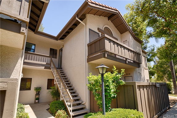 Front view of a two-story building with a staircase and balcony.