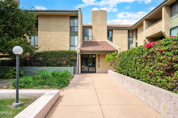Front view of a multi-story residential building with entrance path.