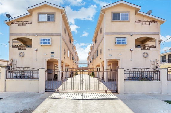 Front view of a multi-story building with gated entrance.