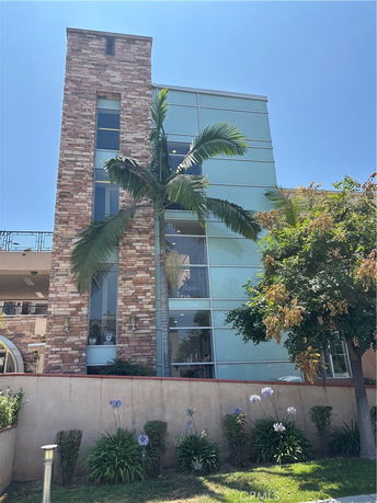 Front view of a multi-story building with a stone and glass exterior.