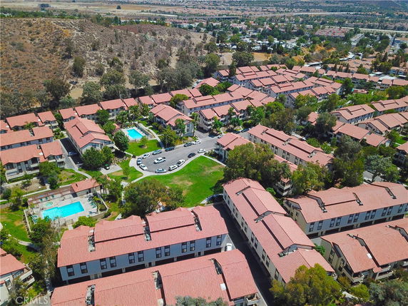 Panoramic view of a residential complex with multiple buildings and two swimming pools.