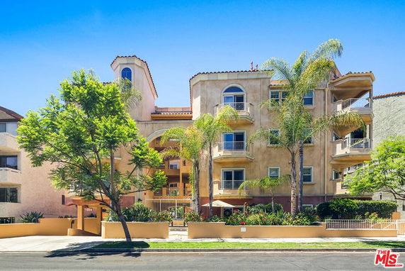 Front view of a multi-story apartment building with balconies.