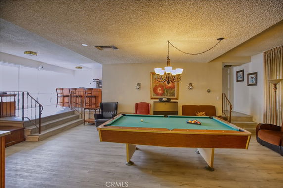 Indoor billiards room with a pool table and bar area.