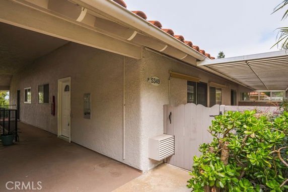 Front view of a house with a covered entrance and side walkway.