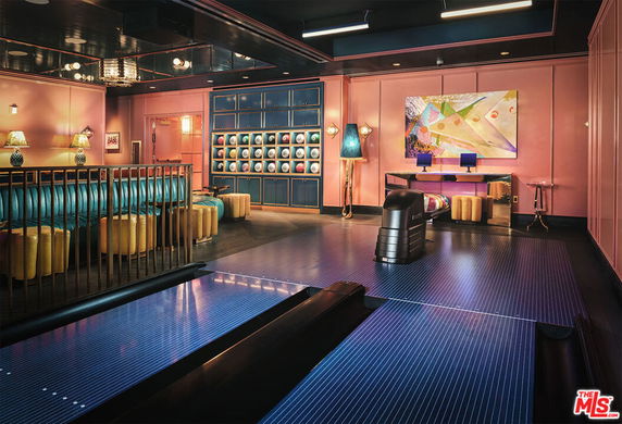 Indoor room with a bowling alley, colorful walls, and seating area.