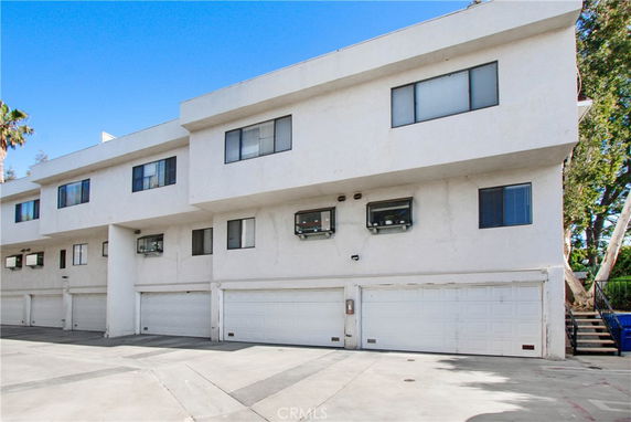 Front view of a multi-story residential building with garage doors.