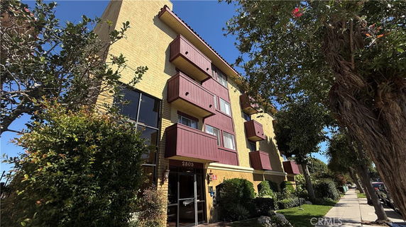 Front view of a multi-story residential building with multiple balconies.