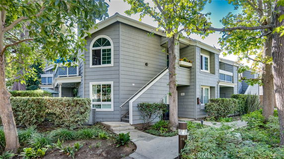 Front view of a two-story residential building with gray exterior and white trim.
