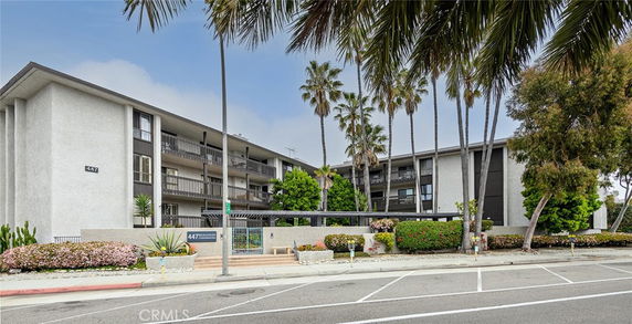 Front view of a multi-story apartment building with balconies.