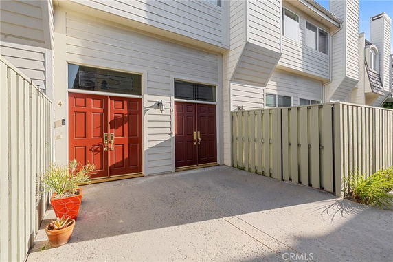 Front view of a building with red double doors and light-colored siding.