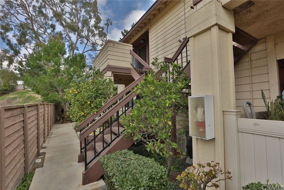 Front view of a two-story residential building with exterior stairs.