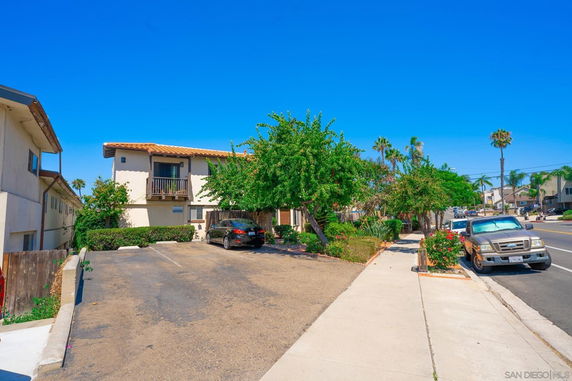 Outdoor parking area in front of a two-story building.