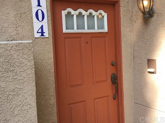 Front view of a house with a red door and number 104 displayed.