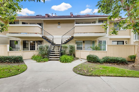 Front view of a two-story apartment building with a central staircase and balconies.
