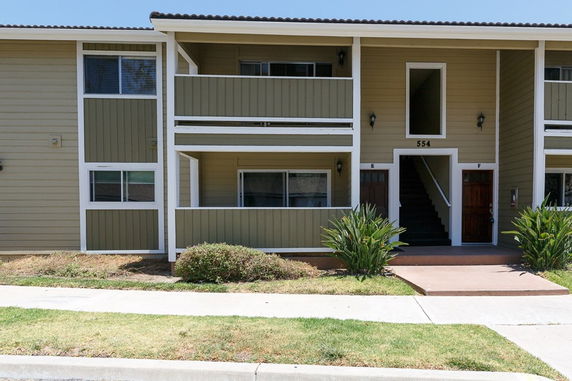 Front view of a two-story residential building with multiple entrances.