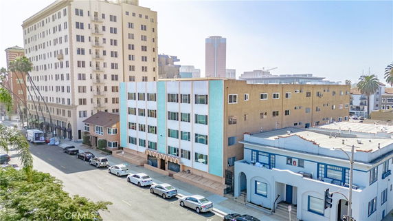 Front view of a mid-rise apartment building with alternating blue and beige sections, located on a city street.
