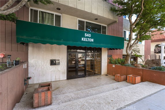 Front view of a building entrance with a green awning displaying the number 540