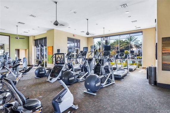 Gym area with exercise equipment and large windows.