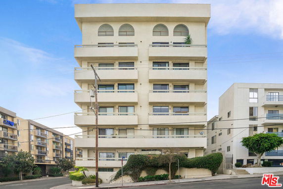 Front view of a multi-story apartment building with balconies.