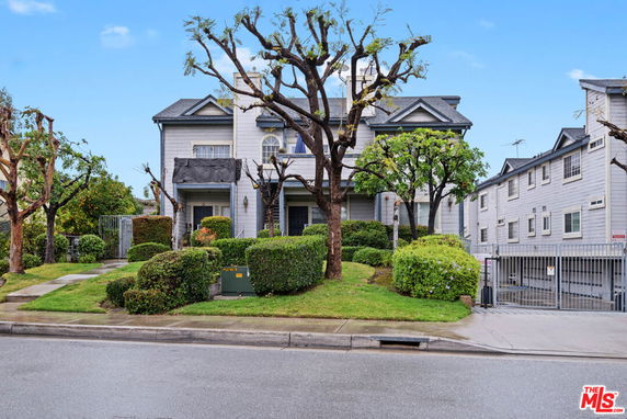 Front view of a multi-story building with distinctive architectural features and well-maintained landscaping.