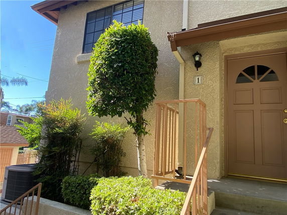 Front view of a house with a single door entrance and steps leading up to it.