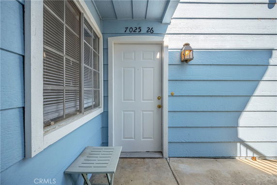 Front view of a house entrance with a blue exterior and a white door.