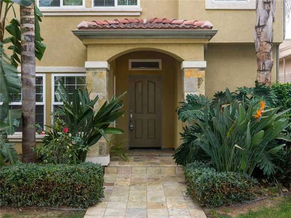Front view of a house with a tiled roof and archway entrance.