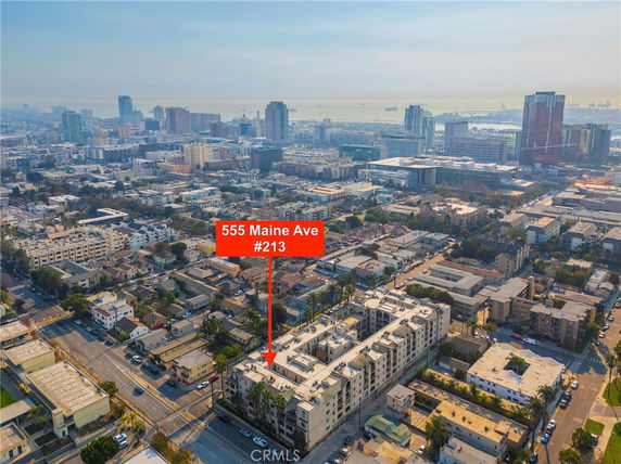 Wide-angle aerial view of a cityscape with a specific building highlighted, showing urban density and skyline.