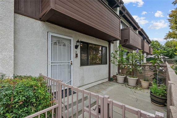 Front view of a townhouse with a small fenced patio area.