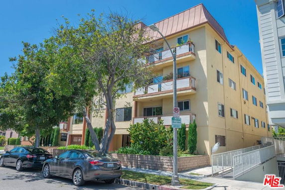 Front view of a multi-story apartment building with balconies.