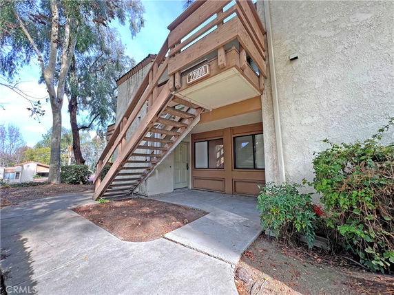 Front view of a two-story building with an external staircase.