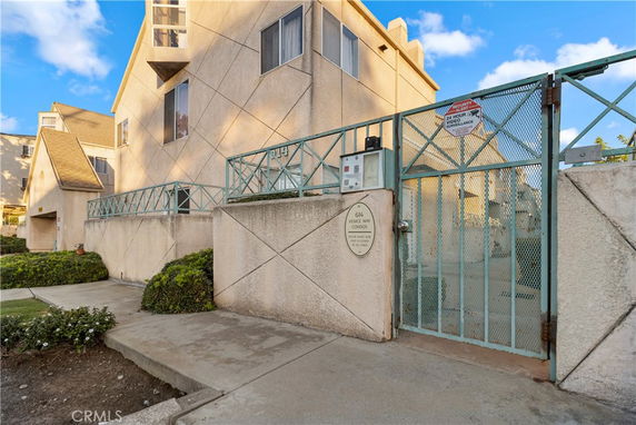 Front view of a multi-story building with gated entrance.
