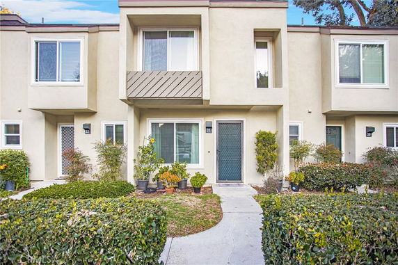 Front view of a two-story townhouse with a prominent entrance and balcony.