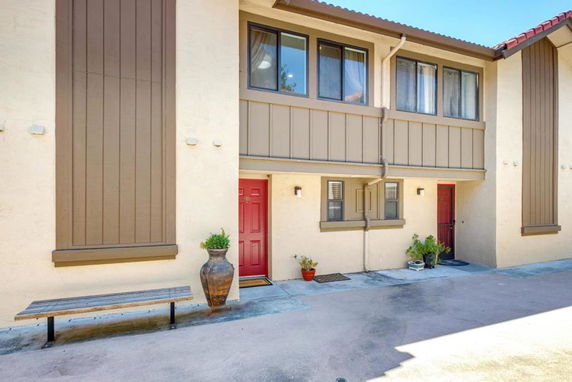 Front view of a two-story building with red doors and light brown panels.