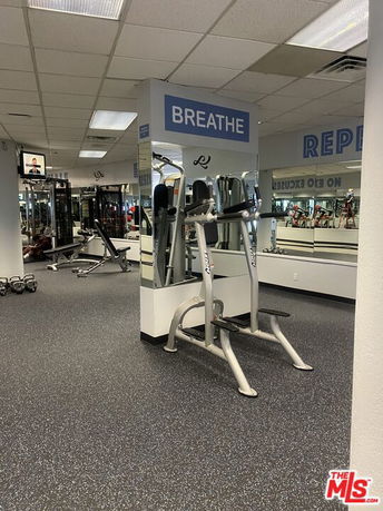 Interior view of a gym with exercise equipment and mirrors.