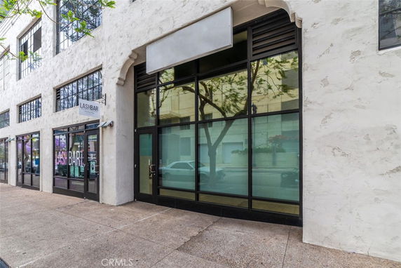 Front view of a commercial building with large glass windows and a sign for LASHBAR.
