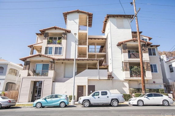 Front view of a multi-story residential building with balconies.