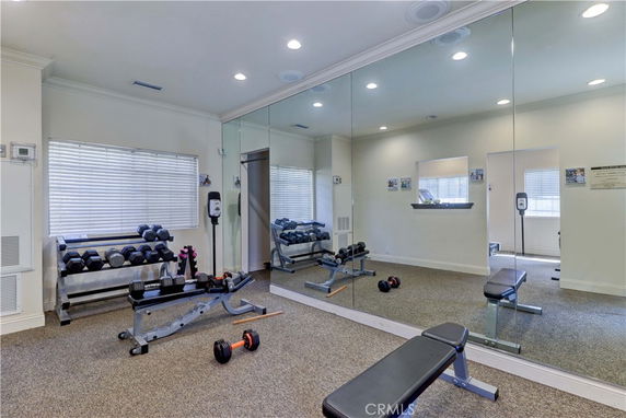 Indoor fitness area with exercise equipment and mirrored walls.