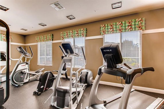 Interior view of a fitness room with exercise equipment such as treadmills and elliptical machines.