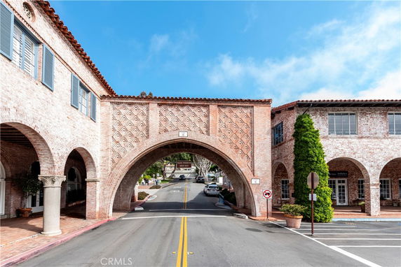 Front view of a brick building with an archway over a road.