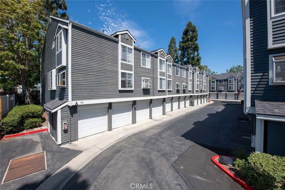 Front view of a multi-story residential building with garages on the ground level.