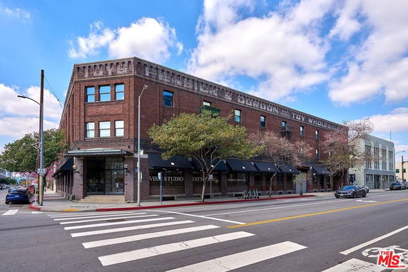 Front view of a multi-story brick building on a street corner.